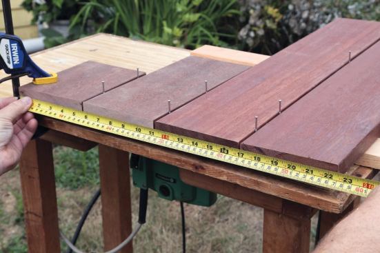 The customer chose 5/4 x 6 mahogany for the decking. I tried laying out the framing on 16-inch centers, which looked okay except for a couple of places where a joist landed directly under a gap in the flooring, so I did a quick mockup with some decking scraps and came up with a 16-13/16-inch layout to avoid the problem.

