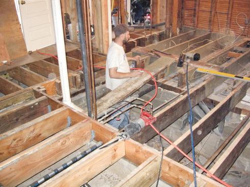 The existing joists were later trimmed or shimmed — and in some cases reinforced with sistered 2x10s — to smooth out the transition into the addition and to prep the kitchen for new wood-strip flooring.