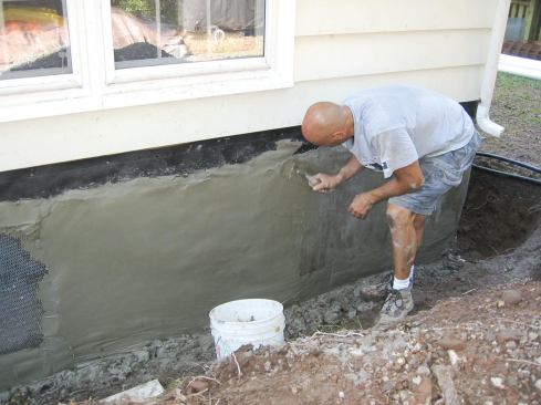 Next, after prepping the wall with 30-pound asphalt felt paper and metal lath, we parged the new and existing walls.