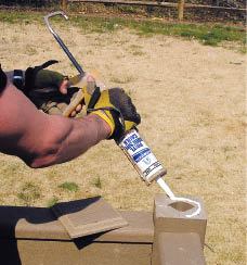 Figure 14. Instead of screwing or nailing post caps in place, the author uses a bead of adhesive caulk. This holds the cap firmly in place — without fastener holes.