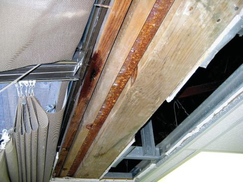 Next I called for removal of the drywall ceiling to further narrow the possible entry location. From what I could see inside, I suspected that the laps in the flashing had failed, if they ever worked in the first place. We had no choice but to rent a  bucket truck and — very carefully, considering the glass below — start deconstruction.