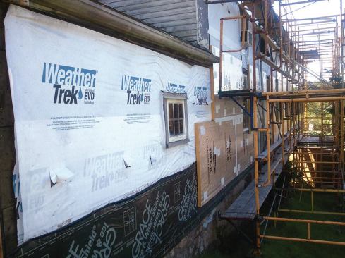 Before the nailing strips went on, cellulose insulation was blown into the walls; housewrap was attached to the original sheathing to keep the cellulose from leaking out.