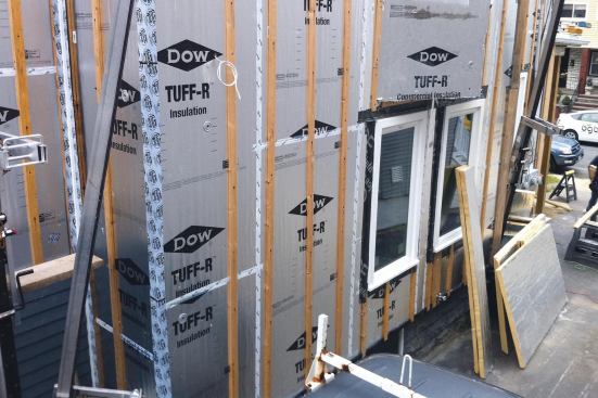 Energy-efficient casement windows were cantilevered beyond the original rough openings, secured with metal ties, then surrounded with snug-fitting rigid foam, which also serves as the wall’s drainage plane.