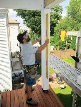 I slide the sleeve up as high as it can go and drive screws on all sides at the bottom, securing it with a space between the sleeve and the post. Next I plumb the sleeve in both directions and drive screws near the top to anchor it. At this point I can use my screws to micro-adjust the sleeve for plumb.