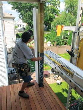 Sleeving the posts. Now I can bring all of the parts for the wrap onto the porch. I start by slipping the pre-assembled part of the sleeve around the post.