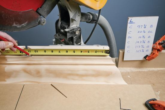 When cutting outside corners, he pulls the measurement from the auxiliary fence, with the short point of the miter flush with the fence.