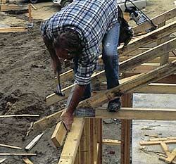 Figure 5. With the efficiency that comes from good preparation, an eaves block is installed (above), then the next truss is rolled up and nailed off (below).