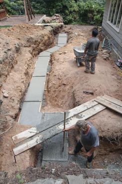 A concrete footing — like what you’d use for a basement wall — was poured to support the new retaining wall.
