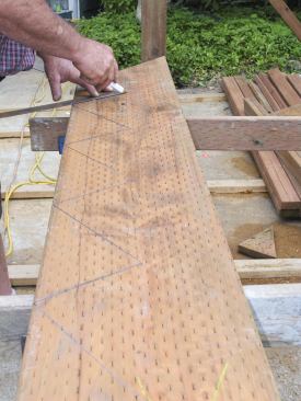 A framing square aligned on the riser and tread dimensions is used to lay out the notches on the jacks.