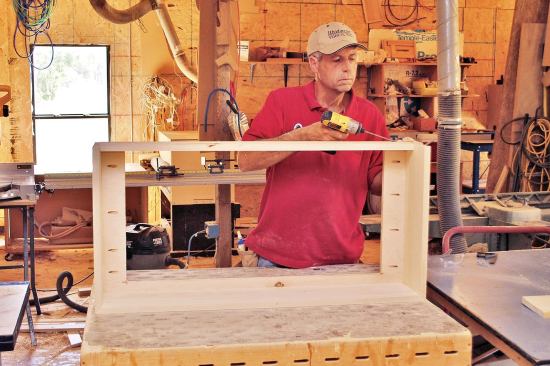 The visible portion of the base was formed by three pieces of 3/4-inch by 9-inch poplar; the corners were mitered and fastened with brads and glue. A 5-inch-wide poplar stretcher on the back tied it all together.