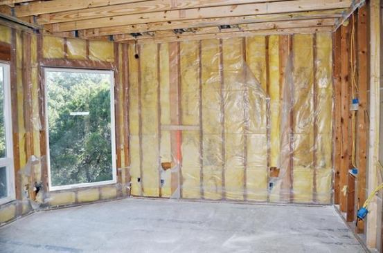 FWater vapor from humid outdoor air has condensed on the cold surface of the interior poly in this 10-year-old home, creating a zone of chronic dampness. Note the black patches of mold on the fiberglass batts.