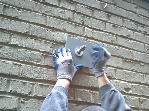 Where the rods emerged from the brick outside, we applied sealant, then capped them with 6-inch-by-6-inch-by-3/8-inch galvanized plates fabricated by a local metal shop.