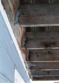 Figure 3. The rotating ledger in this photo was a complete surprise to the homeowner. This ledger has completely pushed the joists out of the hangers, and the deck is at risk of collapse. Ledgers that slowly pull away often rotate from the top, making the hazard less noticeable from beneath.