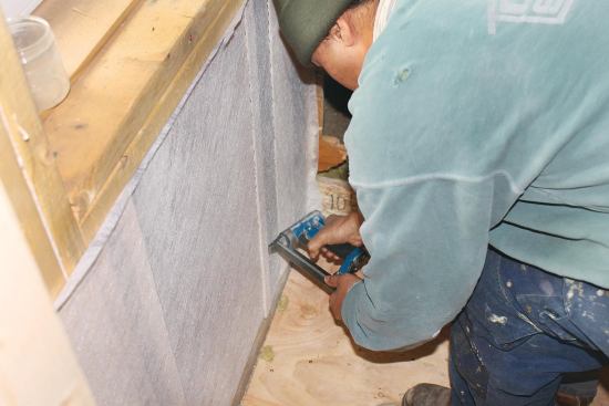 Netting is stretched tight between framing members to minimize bulging of the cellulose.