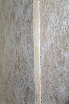 The closely spaced fasteners are driven at an angle just beyond the outer edges of the faces of framing members. This “inset stapling” helps draw the material taut and prevents the cellulose from pushing beyond the framing.