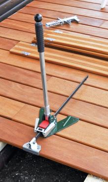 I recently began using the Deckmaster PowerHand, a device that grasps a joist or adjacent deck board to push or pull bowed boards into place.