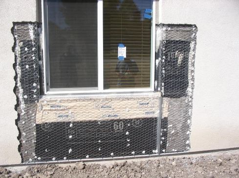 This wall has been repaired and is ready for stucco. The upper leg of the screed is behind the building paper as it should be, but there is not enough clearance to grade.