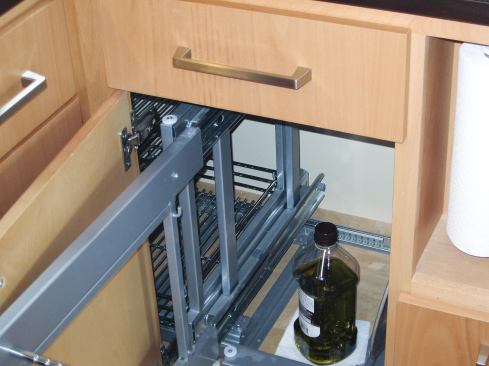 The inside corner base cabinet to the right of the range contains baskets designed to pull out and then to the right, to give access to an inner basket. The problem was that when the hardware was pulled to the right, it ran into the projecting refrigerator panel.