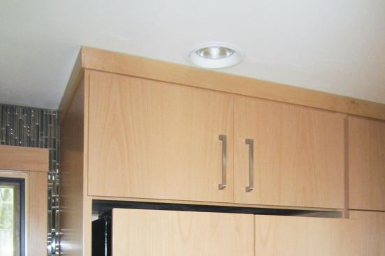 We forgot to allow for the 3/4-inch-thick trim around the top of the refrigerator cabinet. I ripped the trim down to about 7/16 inch thick and cut a very slight amount off its edge to allow it to fit into place.