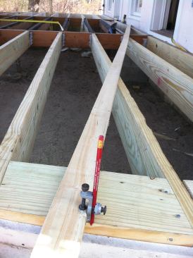 The author replaced the rotted joists with treated framing, then used a trammel arm to scribe the deck’s radius onto blocking installed on the flat around the perimeter of the deck.