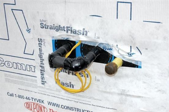 To exclude outdoor air as well as bulk water, this dryer-vent pipe was sealed to the housewrap with a flexible flashing panel and butyl tape.