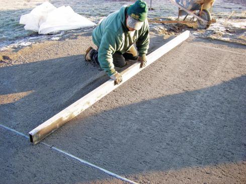 Smaller, 3/4-inch-diameter conduit laid directly on the compacted base guides screeding of a concrete-sand bedding layer.