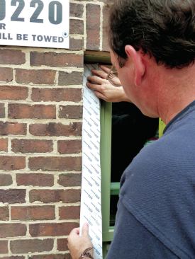 The sides are flashed next with the peel-and-stick flashing tape over­lapping slightly onto the window frame.