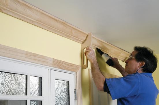 A crown holder positions the molding for precise installation.