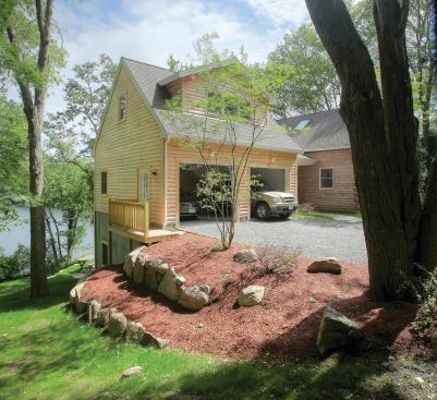 This garage--added on to a log home on a steeply sloping site--has living space above and storage space below. The builder considered several approaches for the foundation and garage floor strong enough to support two vehicles 12 feet above grade.