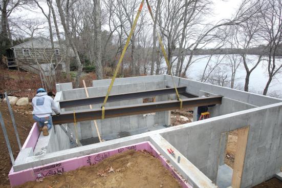 A second floor support beam sits in the formed foundation pockets.