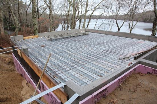 With steel reinforcing mesh on top of the pans and temporary support walls below, we were ready to place the slab.