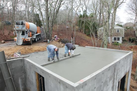 Chalk lines guide the screeding, leaving the slab slightly sloped for drainage.