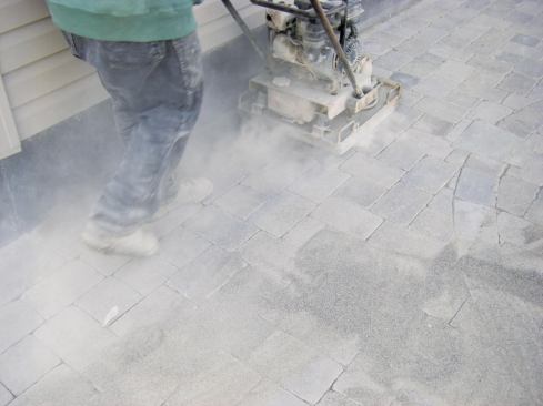 Many types of pavers are best installed on a loose bedding layer, then set with a plate compactor. This creates a uniformly flat surface and drives sand into the joints to lock the pavers in place.