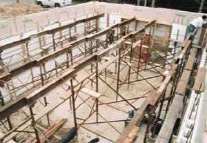 The deck pan was supported by a series of 4x6-foot steel frames and braces, topped by sectional steel I-beam strongbacks. The strongbacks were arranged in four parallel rows on nominal 7-foot centers.