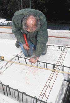 To eliminate a moment connection, steel rebar connecting the floor system to the walls was installed independent of the wall rebar, providing for possible movement in the floor to be released at the top of the wall.
