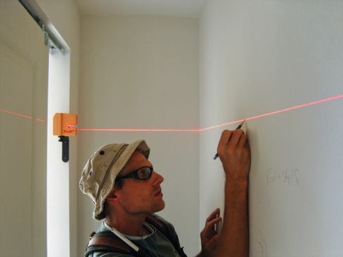 The PLS180 projects a particularly wide horizontal beam and is being used here to lay out shelf cleats in a closet. It's supported by a magnetic bracket that's stuck to the metal corner bead.