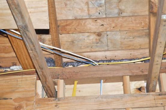 Smaller gaps between the framing and sheathing at the eaves — and around pipe and wire penetrations in partitions — were sealed with black canned foam.