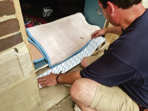 A second layer of peel-and-stick tape goes over the sill section of the buck.