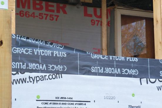 With a cut where the rough sill joins the jamb at the far end, half of the flashing strip is folded down onto the sill. The process is repeated at the other corner. If you're working alone on a window, do one corner at a time to prevent the sticky flashing membrane from wrinkling during application.