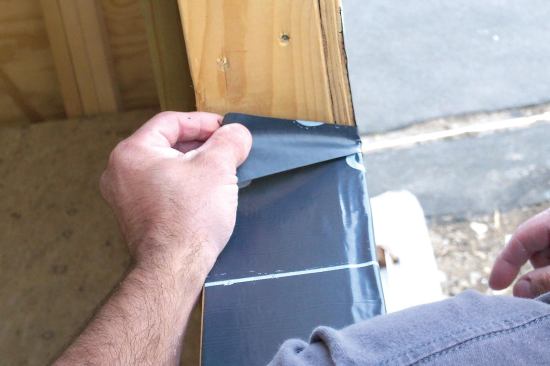 One end of a bow tie is adhered to the flashing membrane outside the opening, the other half folded to the inside to seal the joint between the rough sill and jamb.