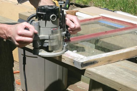 Using a plunge router, the author centers the slot for the bottom tube seal 5/8 inch from the face of the sash.
