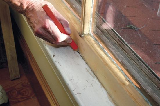 Before the weatherstripped sash can be reinstalled, the stool must be scribed and trimmed to allow for the thickness of the brush seals on the face of the side rails. A 1/16-inch-wide gap, scribed with a carpenter’s pencil, allows for expansion.