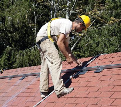 After snapping lines marking the position of the rafters, the installer lays out the first extruded-aluminum mounting rails, which will be fastened to each rafter with a 5/16-inch hot-dipped lag screw.