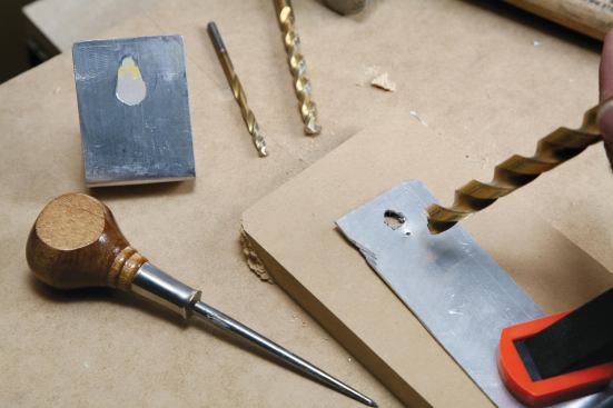 The jig is easy to make from a scrap of sheet metal: Drill a keyhole,