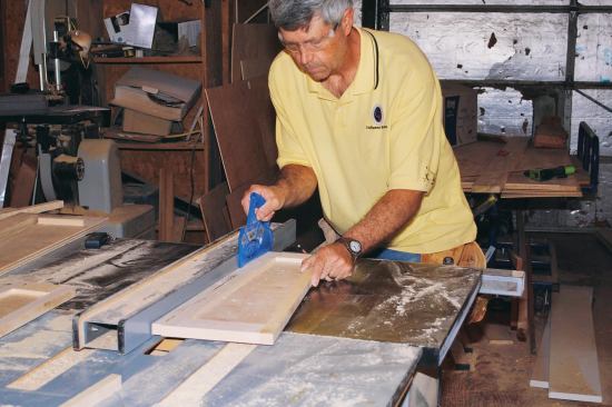 In preparation for assembly, I ripped 3/4 inch from the 1-7/8-inch-wide stiles of two of the frames. I also cut a 15-degree angle on the bottom rail of each frame, using the table-saw miter gauge and the wedge-shaped spacer to hold the frame square to the blade.