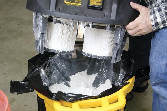 These filters were nearly buried in plaster dust and yet continued to draw because the self-cleaning mechanism prevented them from clogging. This machine is being used with an open-top plastic liner bag.