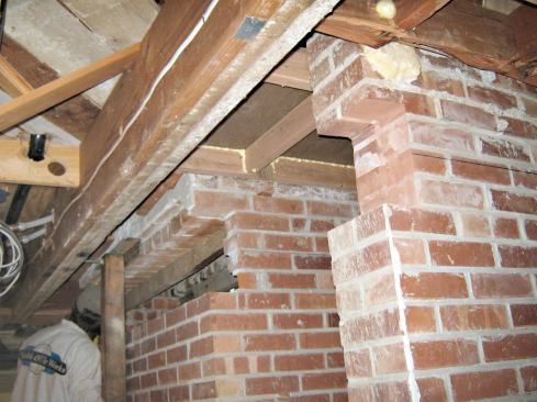In preparation, we installed 3-inch tube supports at the end points, where they would be hidden in cabinets and wall framing, while the mason removed the brick to make way for the first beam. The channel created for the beam was about an inch too high, but the space would be filled later with stone shims and nonshrink grout. For now, it gave us the needed clearance to make the installation easier.