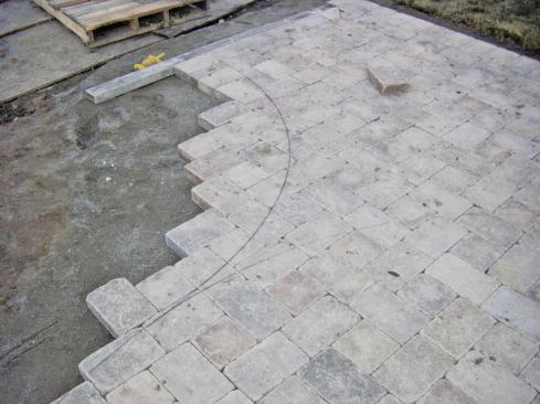 For many curves, the author lays the pavers beyond the line of the curve and cuts them in place.