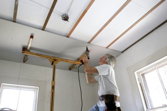 For most ceilings, drywall can be applied directly over the plaster. On this job, the furring created a space to run conduit for overhead lighting. When covering plaster walls (photos below), use 1/4-inch drywall to minimize the effect on trim profiles. To ensure a permanent bond, use both constructive adhesive and screws to fasten the thinner material.