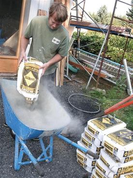 The author finds that for less than one yard of concrete, site-mixing is cheaper than ordering it ready-mixed and paying short-load fees. Sixty 60-pound bags of concrete mix — enough to make a yard — at $2.90 each costs $174. 